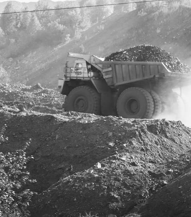 Large off-highway dump truck hauling earth and rocks at a mining or construction site
